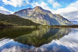 The mountains are reflected in the smooth water of the fjord. The most famous and picturesque fjord