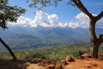 Panoramic view from Barichara, Colombia over green landscape to mountains with blue sky and white