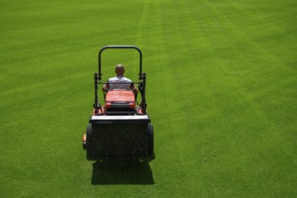 Mowing grass at the football stadium in Lubin, Poland, Europe