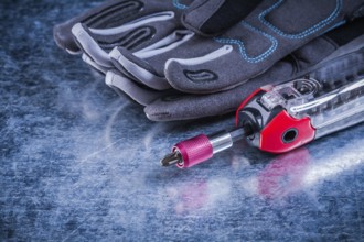 Threaded muunction screwdriver fabric protective gloves on metallic background