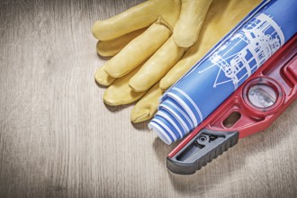 Safety gloves construction level plans on wooden board
