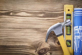 Construction level plan claw hammer on vintage wooden board copy space