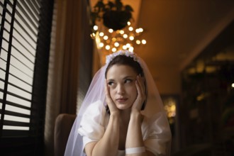 Bride appears thoughtful, gazing in a softly lit evening cafe