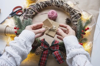 Pack a gift for Christmas and new year in kraft paper, cones, tape, scissors. Tags with mock up,