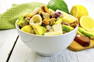 Salad from shrimps, octopus, mussels and calamari with avocado, lettuce, lemon and pineapple in a