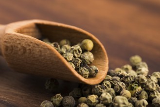 Green peppercorns on a wooden background