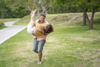 Man running in a park carrying his girlfriend in his arms