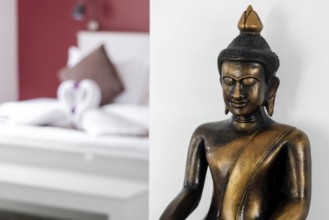 Bronze buddha statue interior design detail in modern asian home living room