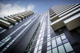 Skyscaper in a city seen from below under a blue sky