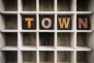 The word TOWN written in vintage ink stained wooden letterpress type in a partitioned printer's