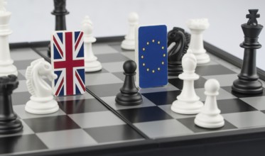 Chess pieces and flags of the European Union and the Britain on a chessboard. The concept of the
