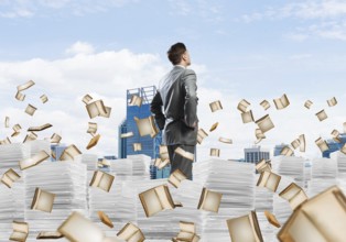 Confident businessman in suit standing on pile of documents among flying books with cityscape on