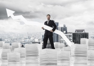 Young and ambitious businessman in suit holding big white arrow in hand and pointing away while