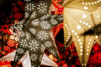 Decorative, illuminated stars with an artistic pattern create a warm, Christmassy atmosphere at a