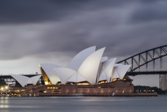 SYDNEY, AUSTRALIA, DECEMBER 03 2023: Sydney Opera House and Harbour Bridge at dusk during a summer