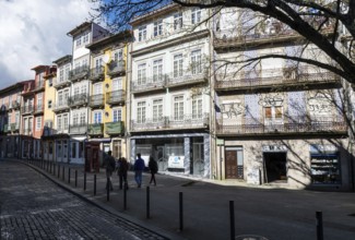 Street scene, passers-by in front of historic house facades in the historic centre, city of Porto,