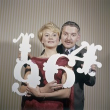 Fun with numbers in the 1960s. A woman and a man are holding different numbers in their hands 1, 4,