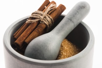 Cinnamon sticks with pure cane brown sugar in mortar