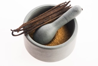 Brown vanilla sugar and vanilla beans in mortar