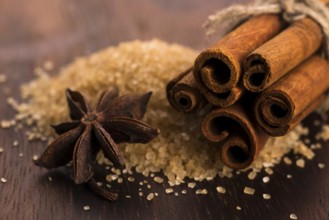 Cinnamon sticks with pure cane brown sugar on wood background