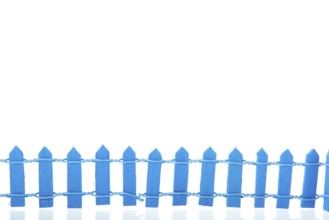 Miniature blue fence isolated over white background