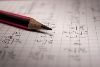 Pencil on notebook, full of mathematical formulas