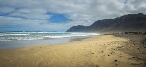 Panorama view on Famara beach on the Canary Island of Lanzarote, with some windsurfing in the far