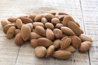 Close-up of almonds, piled up on wooden table
