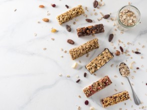 Granola bar with copy space. Set of different granola bars on white marble table. Shallow DOF. Top