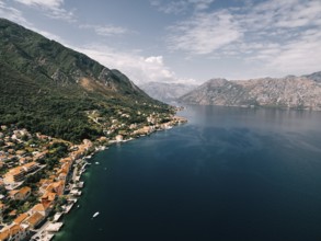 Red roofs of houses with private piers on the shores of the Bay of Kotor. Dobrota, Montenegro.