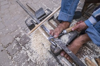 Craftsman carpenter working with his feet, street of the souk, marrakesh, morocco