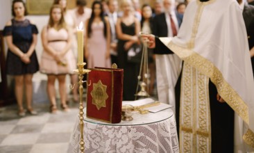 Wedding ceremony in an Orthodox church. The priest in a white cassock stand in the church at the