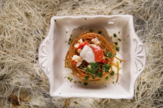 Presentation in flat nest of spaghetti sauce full of scallops
