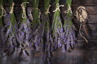 Small bunches of lavender flowers presented on dark wood background