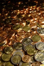 Euro coins of all denominations fill the motif. Portrait format. Euros of all coin values fill in