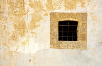 Metallic open window on a yellow grungy wall with various intersting textures