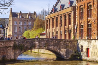 Bruges, Belgium, April 10, 2016: Scenic cityscape with houses, people on bridge and canal in