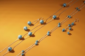 Turquoise necklaces over orange background, selective focus
