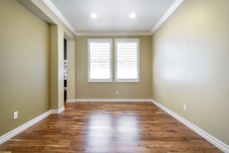 Bright beige large empty room with wood floor, molding and windows. Modern bright room, interiors