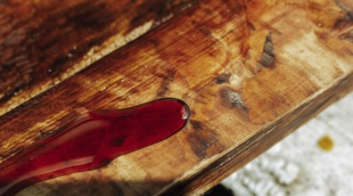 Close-up of wood stained red, emphasizing grain and texture