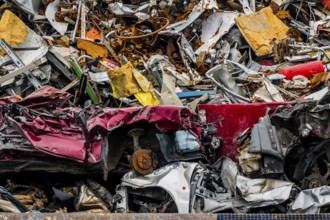 Alte Autos wurden in einer Müllpresse verschrottet. Alteisen und Abwrackprämie für Autowracks,