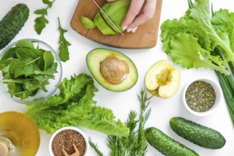Woman cooking salad of fresh green vegetables and herbs. Cooking healthy diet or vegetarian food.