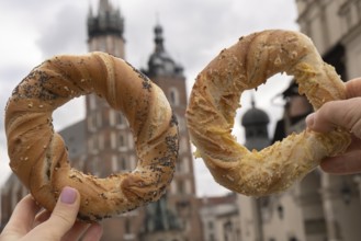 Tourist woman eating bagel obwarzanek traditional polish cuisine snack waling on Market square St.
