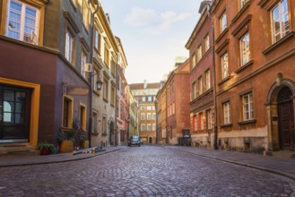Narrow street of Old Town in Warsaw at sunrise