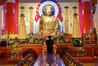 Manhattan, New York City, New York, USA, North America, Person praying in front of a large Buddha