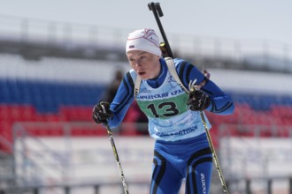 Sportsman biathlete Protasov Dmitry skiing on ski track distance biathlon stadium during Junior