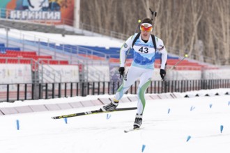 Sportsman biathlete Zlobin Vladislav Khanty-Mansiysk skiing on distance biathlon stadium. Open