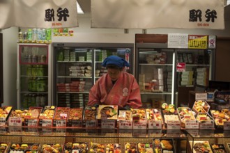 23 Dec 2017, Kyoto, Japan, Asia, A woman sells ready meals and drinks in a train station kiosk in