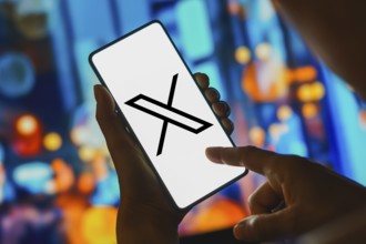 In this photo illustration, the X logo is displayed on a smartphone screen