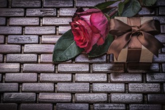 Red rose giftbox on wicker wooden place mat